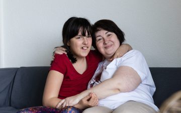 Mutter und Tochter umarmen Sofa